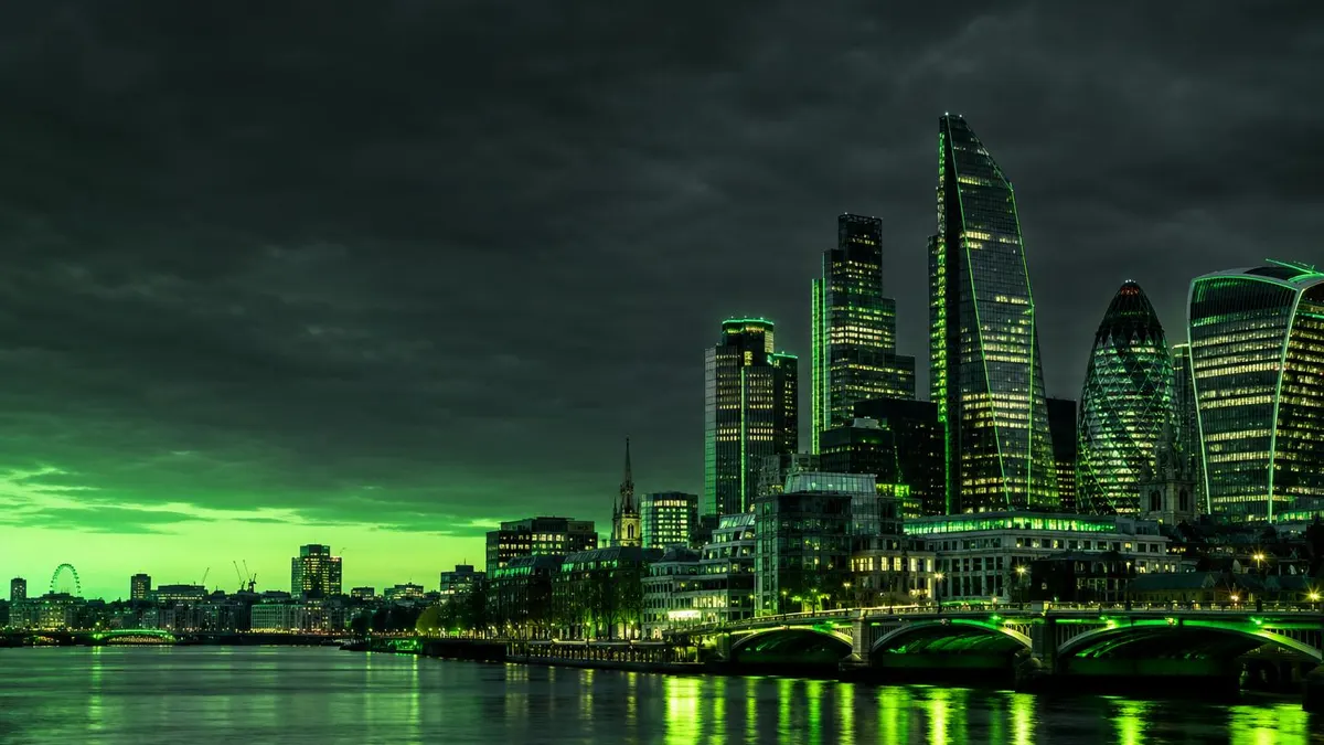 Gedung-gedung distrik keuangan London di tepi sungai dengan langit malam kehijauan