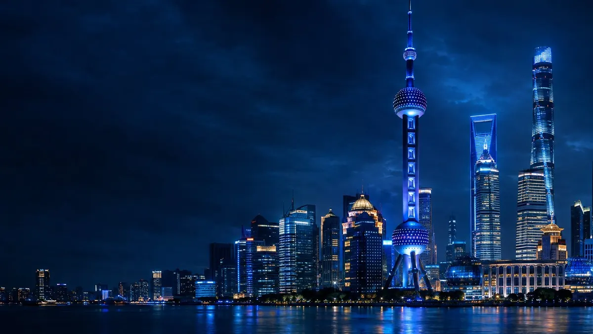 Kawasan Lujiazui di Shanghai pada malam hari dengan menara berlampu biru di tepi sungai